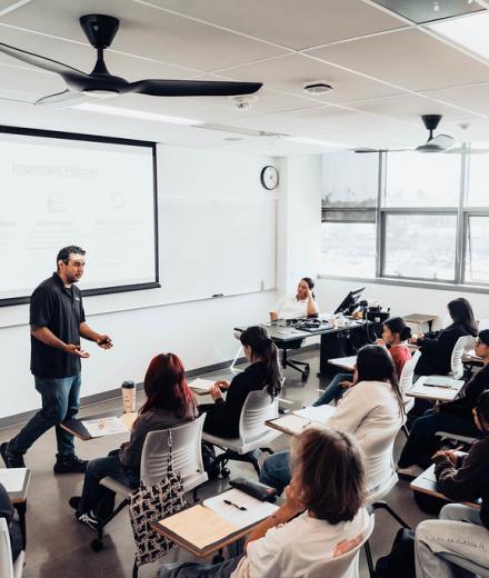 a teacher teaching in front of students in a classroom