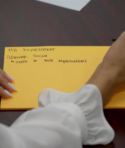 a person writing notes on a notecard