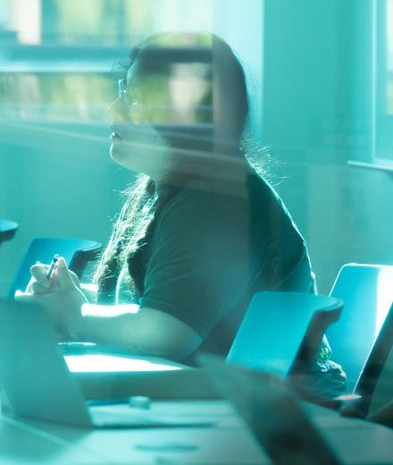 two students working at a table with laptops