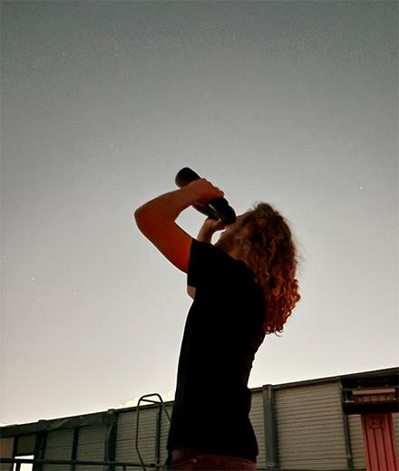 person using binoculars to look at night sky