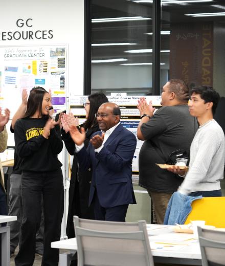 a group of students and staff clap their hands in celebration