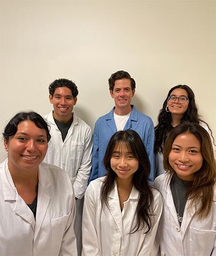 Dr. Michael Carlson and student researchers in lab coats