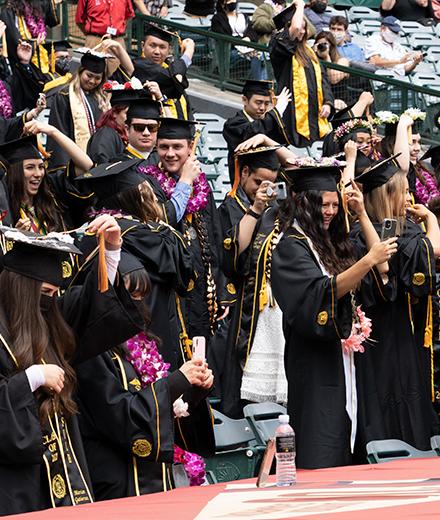 students in caps and robes celebrating graduation