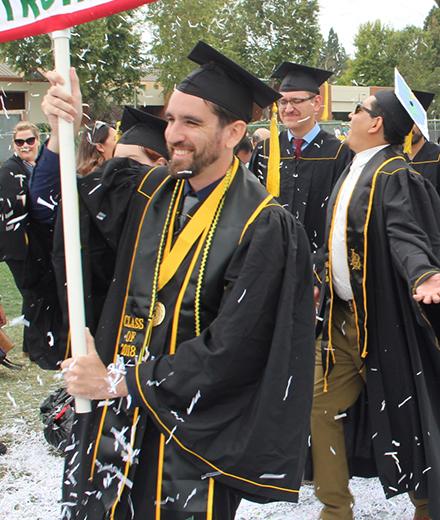 graduating students walking through confetti