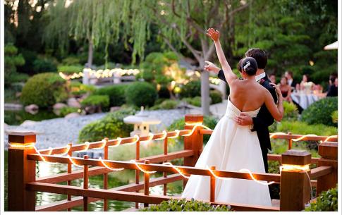 Bride and groom wave to their wedding guests from the koi deck.
