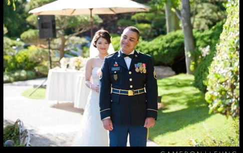 Photo of a groom in a formal military outfit just before he turns to see his bride behind him.