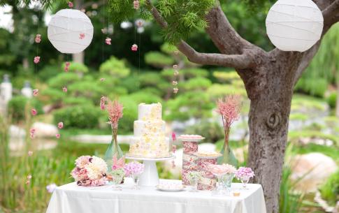 Wedding cake display with lanterns in the foreground and the garden in the background