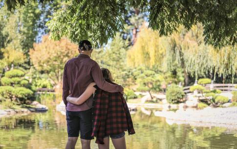 Photo from behind a couple looking out across the Japanese Garden pond