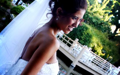 A dutch-angled portrait of a bride in front of black rock beach at the Japanese Garden.