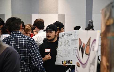 Engineering student holds senior design board