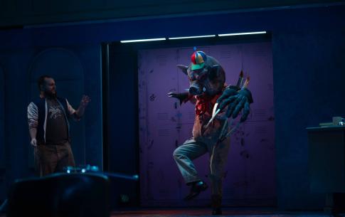 A huge mascot, hald pig, half demon sances on stage