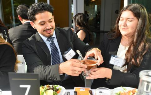 Students pass each other salad dressing at the dinner table
