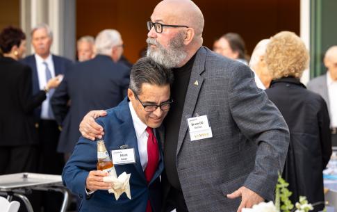 Man with beard hugging man with gray and brown hair