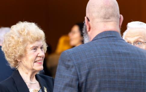 Woman with blonde hair speaking to bald man