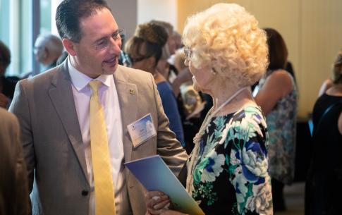 A man in a tie talking to a woman