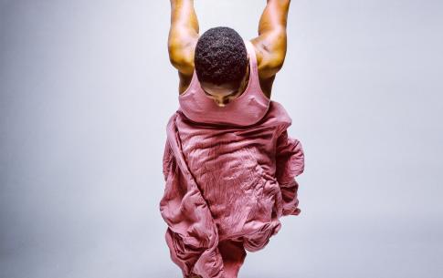 Aimée Wodobodé dances in a pink dress against a white background