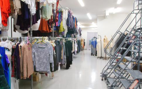 Dance Costume Stock is a large well lit space with double stacked racks of costumes spanning the space.