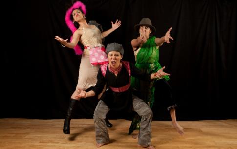 A group of three lively female performers in upbeat costumes.