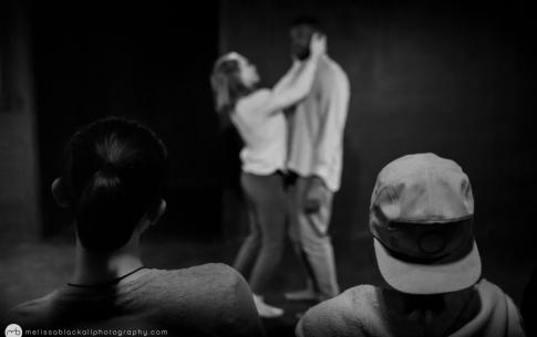 audience members watch a duet between T and a female dancer in this black and white photograph