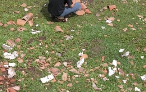 Don playing discarded roof tiles.