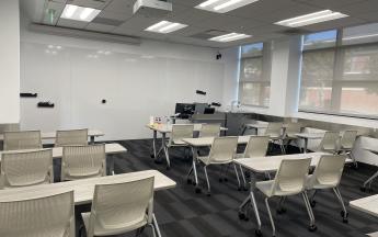 many desks and chairs faced towards the front of the classroom