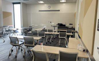 many desks and chairs facing the front of the classroom