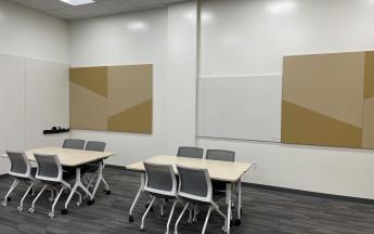 two tables with four chairs and two whiteboards