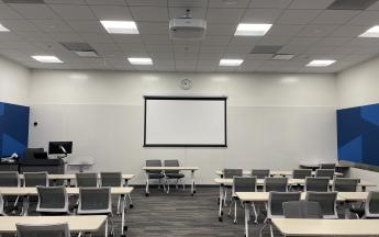 whiteboard and screen at the front of the classroom