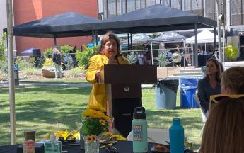 A woman speaks at a podium at an event.