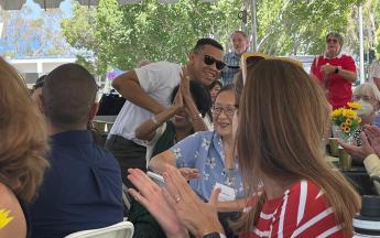 A man stands up to be recognized at a luncheon.
