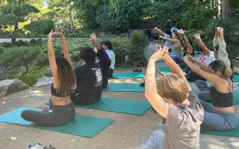 Students sitting on yoga mats and stretching