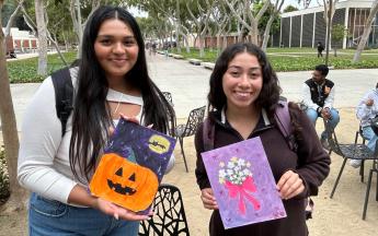 students posing and holding up their painting