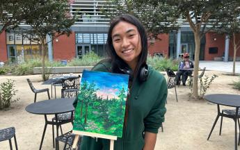student with her painting posing