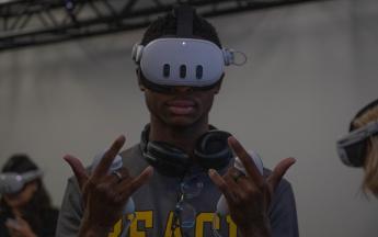 student male with goggles and hands up