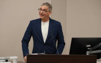 person speaking animatedly behind podium