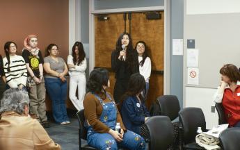 group of students standing around student speaking into mic