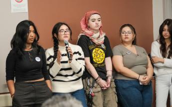 student speaking into microphone with other students