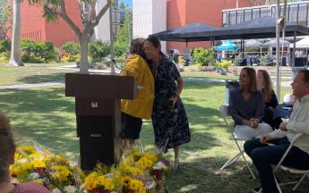 Two women hug at an awards ceremony at CSULB