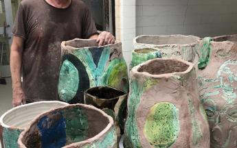 Artist in residence Roger Herman loading pots for firing, 2019.
