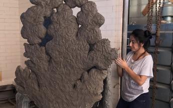 Artist in residence Anabel Juarez building a sculpture on a kiln car, 2019.