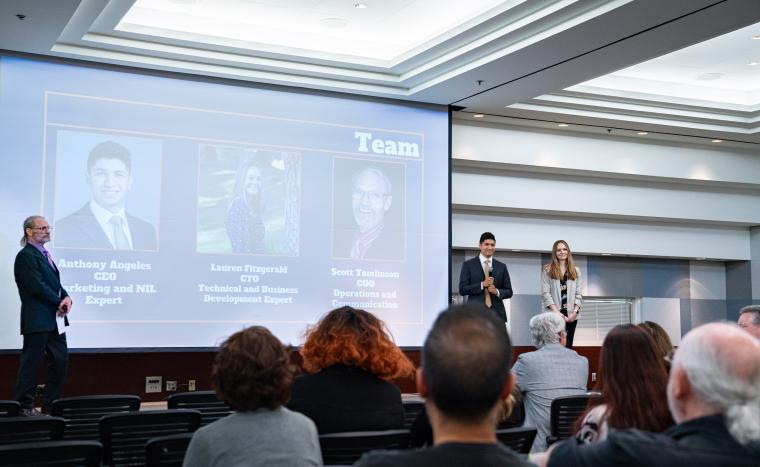 group of 3 presenting a deck to an audience