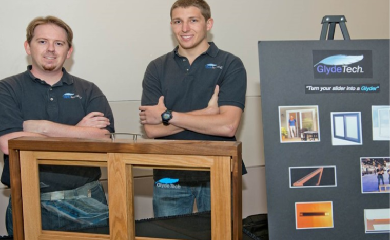 two men standing in front of a wooden box with arms crossed
