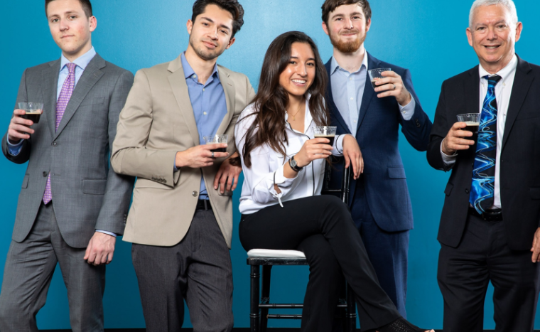 group of people holding coffee smiling at the camera