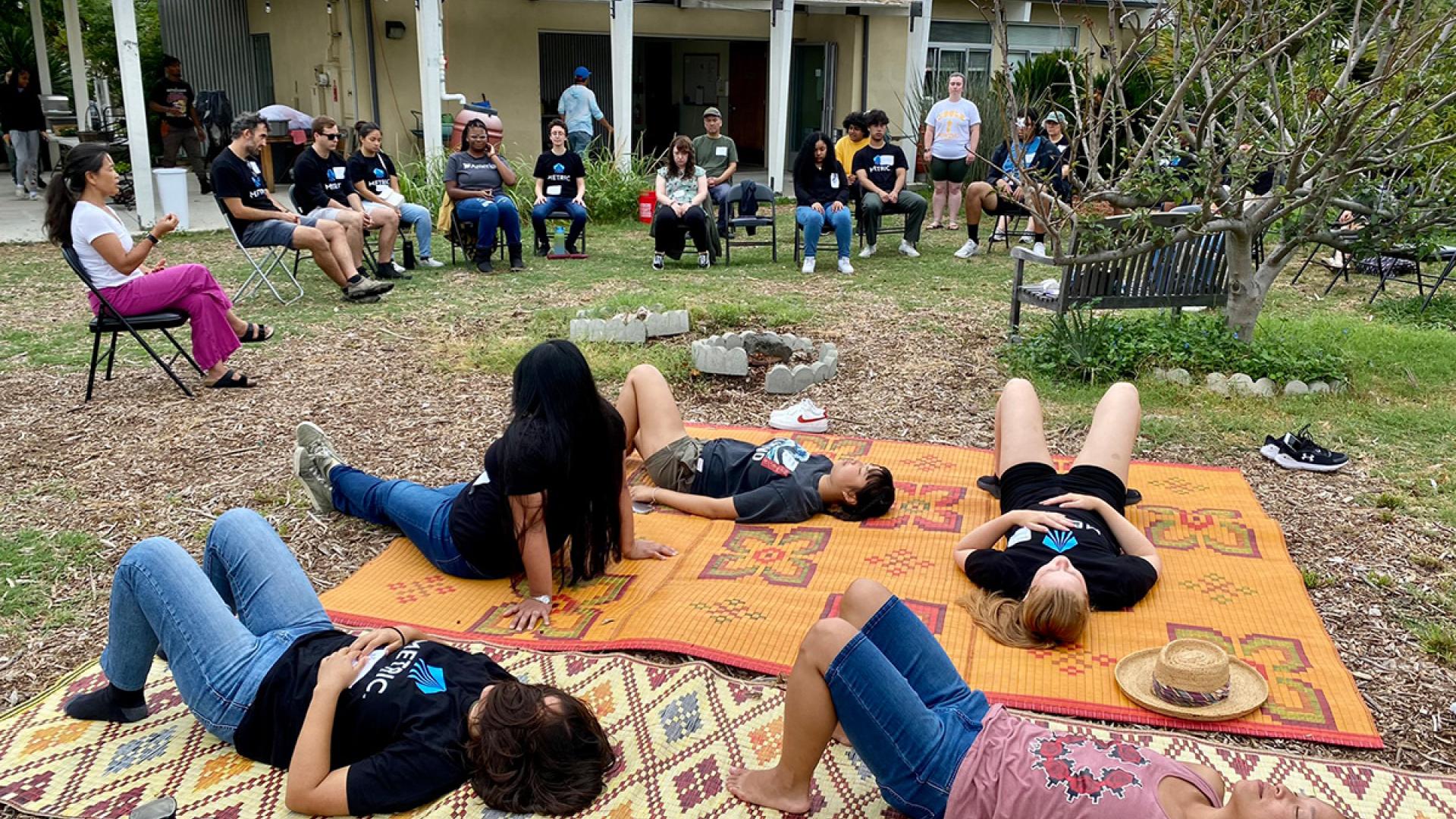 students meditating on blankets