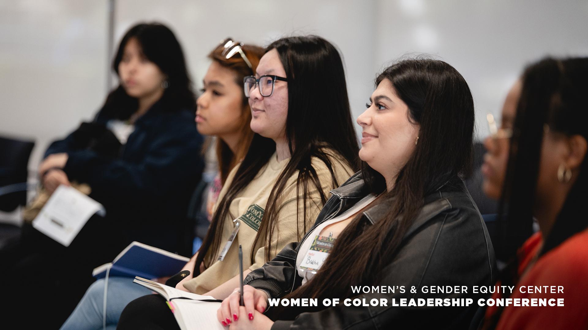 Women attentively listening to a presentation at leadership conference.