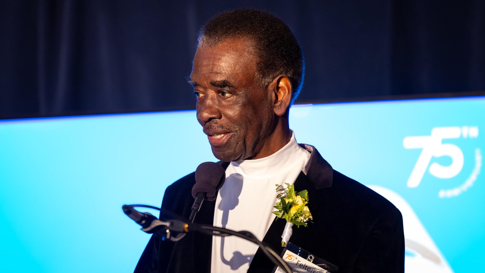 Distinguished Alumni honoree Felton C. Williams speaks into a microphone