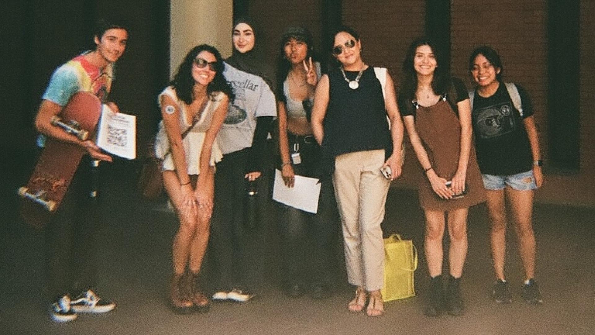 students and professor standing together looking cool