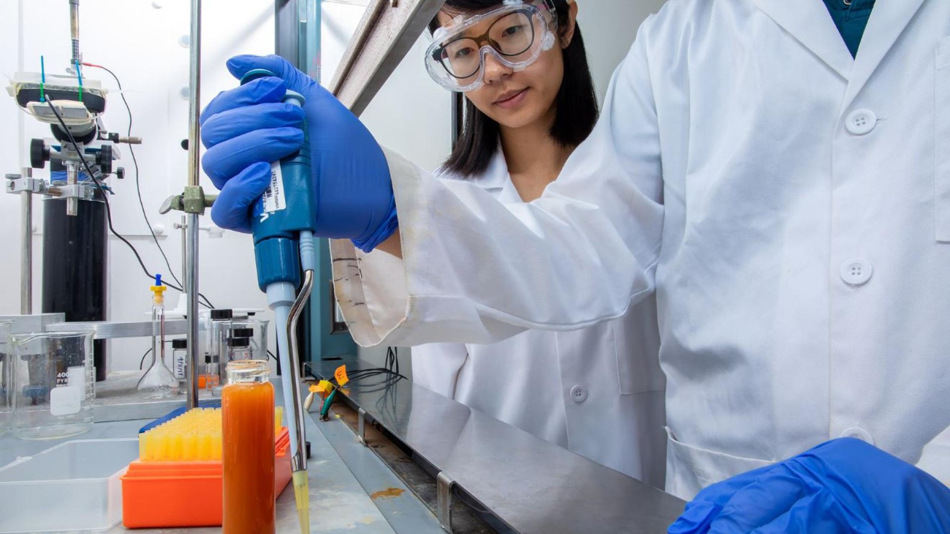 A woman in lab coat oversees lab work