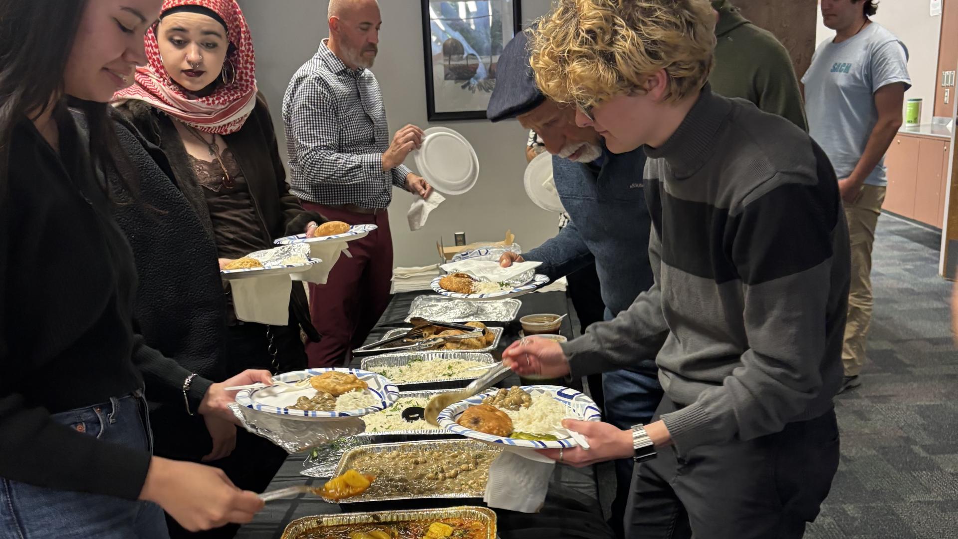 people filling plates with vegan food