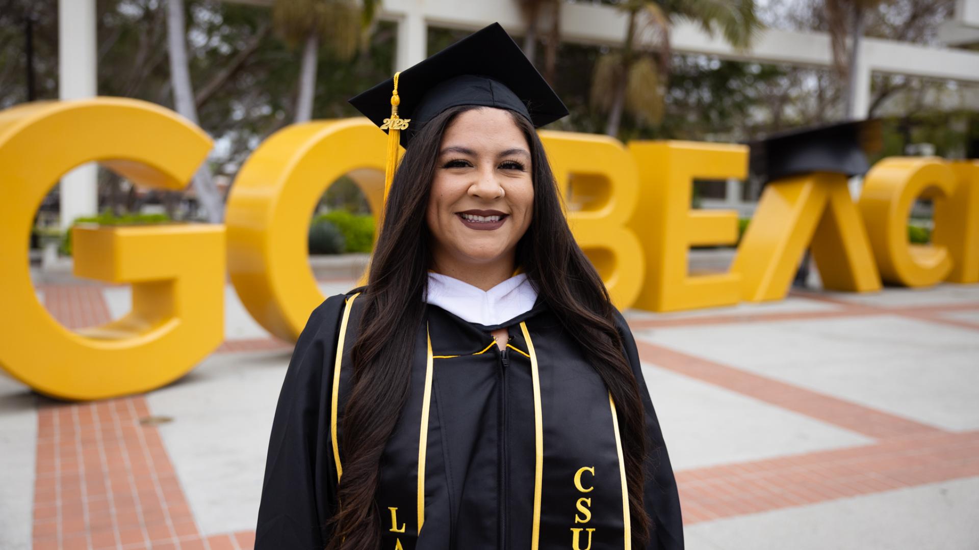 student standing in front of Go Beach sign